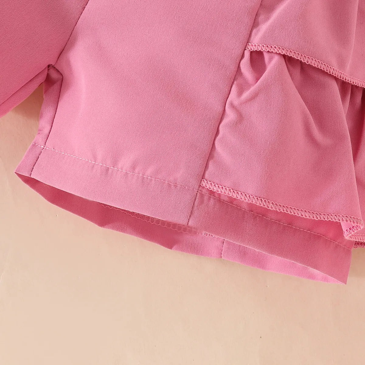 Set de lazo con perlas en pantalón corto y gorro.