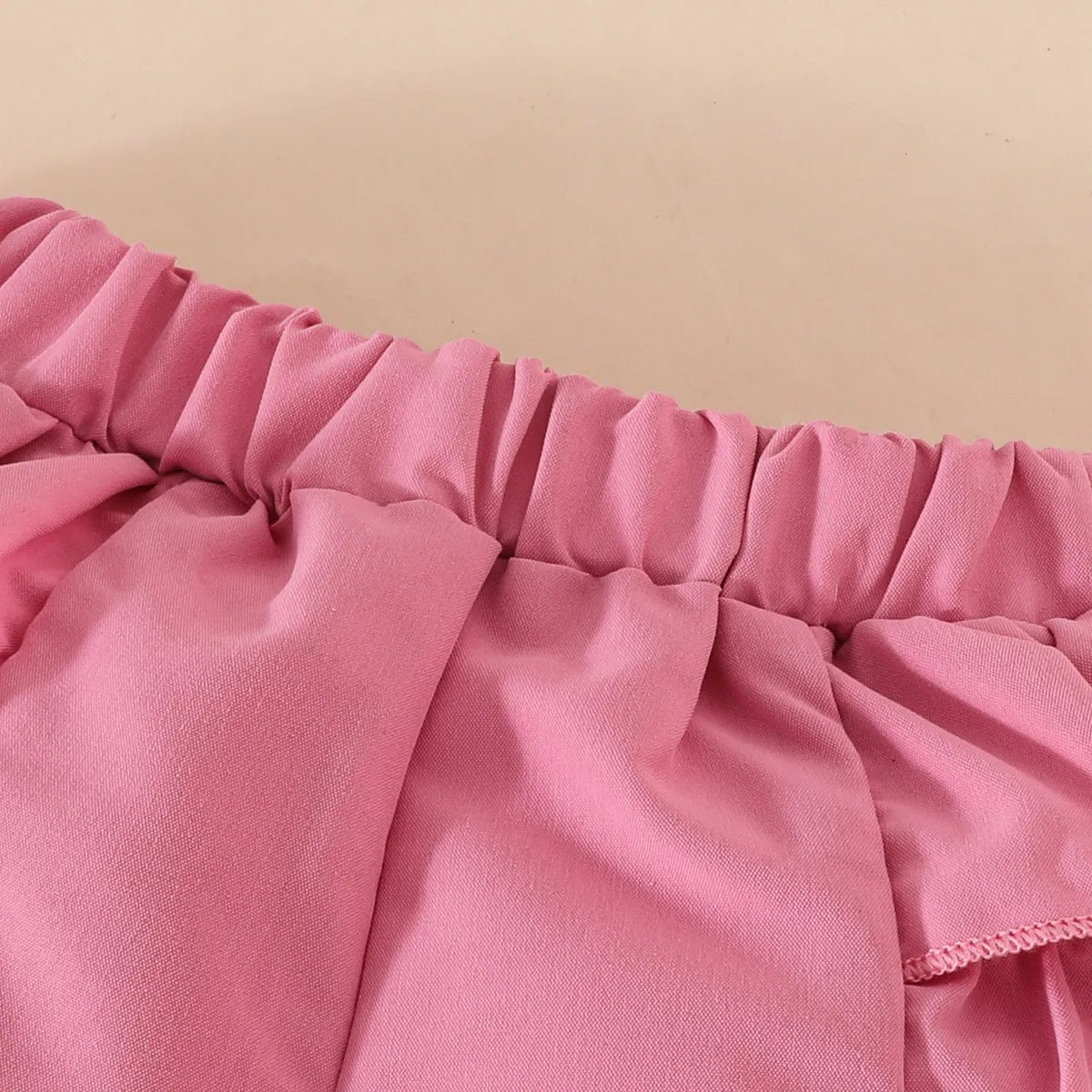 Set de lazo con perlas en pantalón corto y gorro.