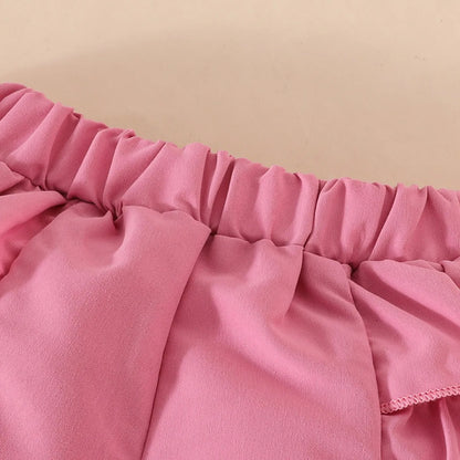 Set de lazo con perlas en pantalón corto y gorro.